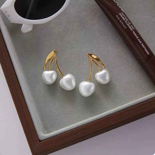 Front view of 18K Gold-Plated Pearl Cherry Earrings in Gold showing neckline and sleeve details