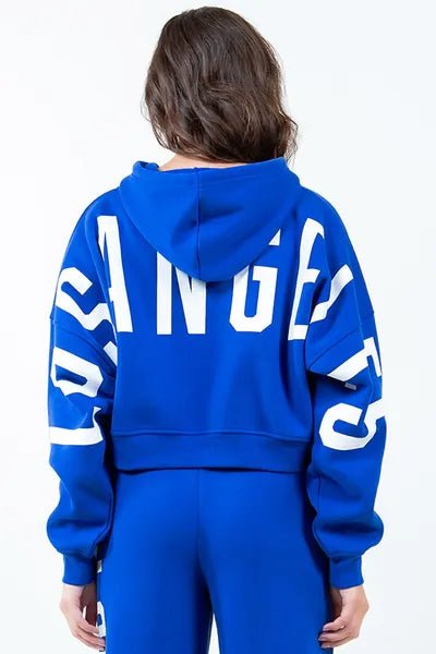 Front view of American Bazi Letter Graphic Long Sleeve Drawstring Cropped Hoodie in Royal Blue showing neckline and sleeve de