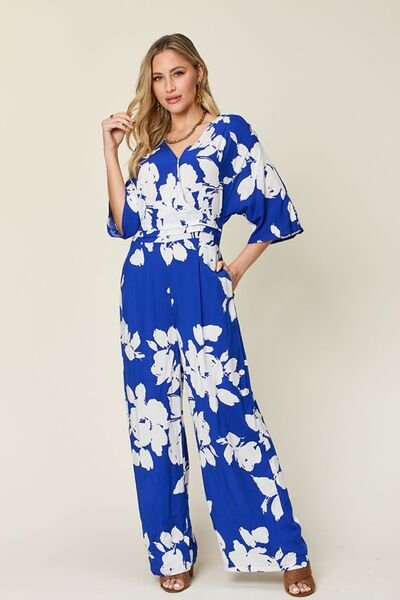 Front view of Double Take Full Size Printed Tie Back Wide Leg Jumpsuit in Royal  Blue showing neckline and sleeve details