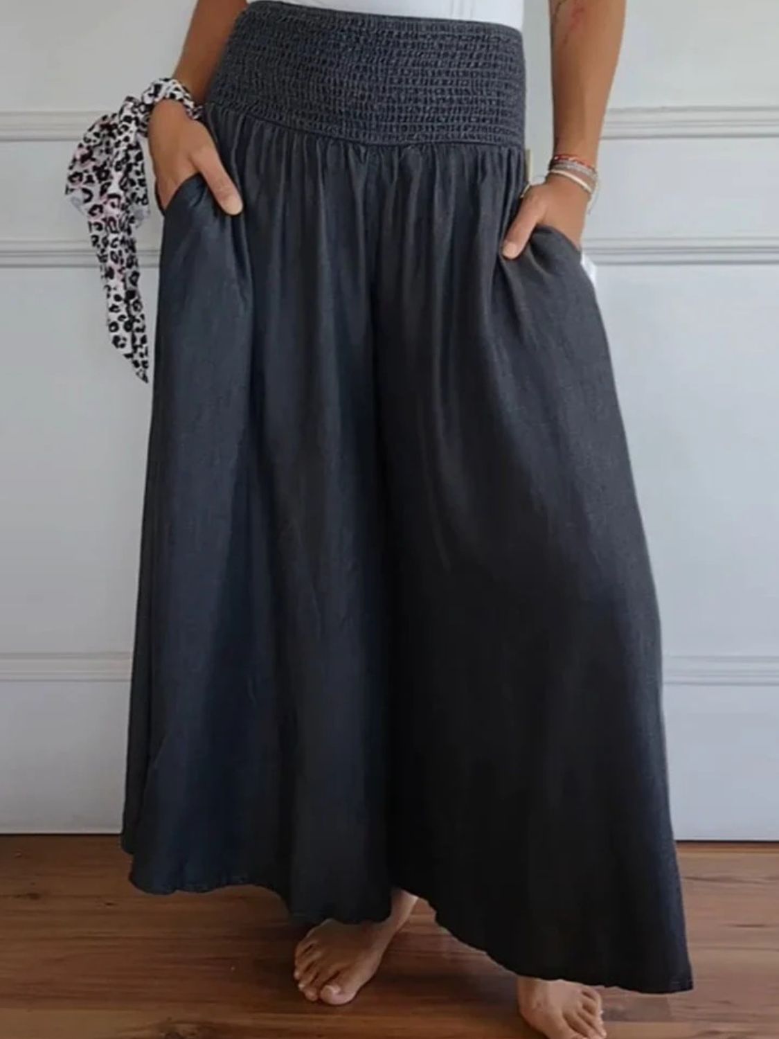 Front view of Full Size Smocked Wide Leg Pants with Pockets in Black showing neckline and sleeve details