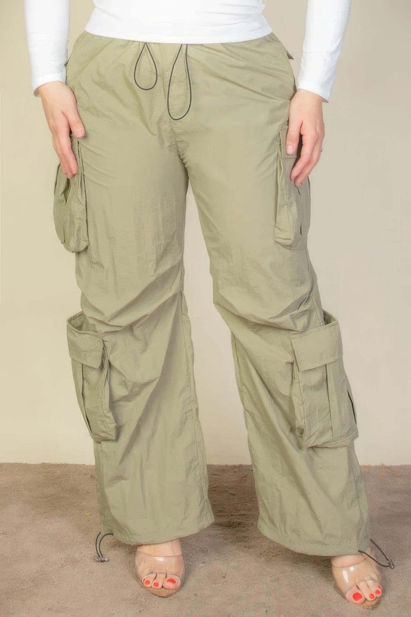 Front view of Plus Size Flap Pockets Drawstring Ruched Parachute Pants showing neckline and sleeve details (100% nylon)