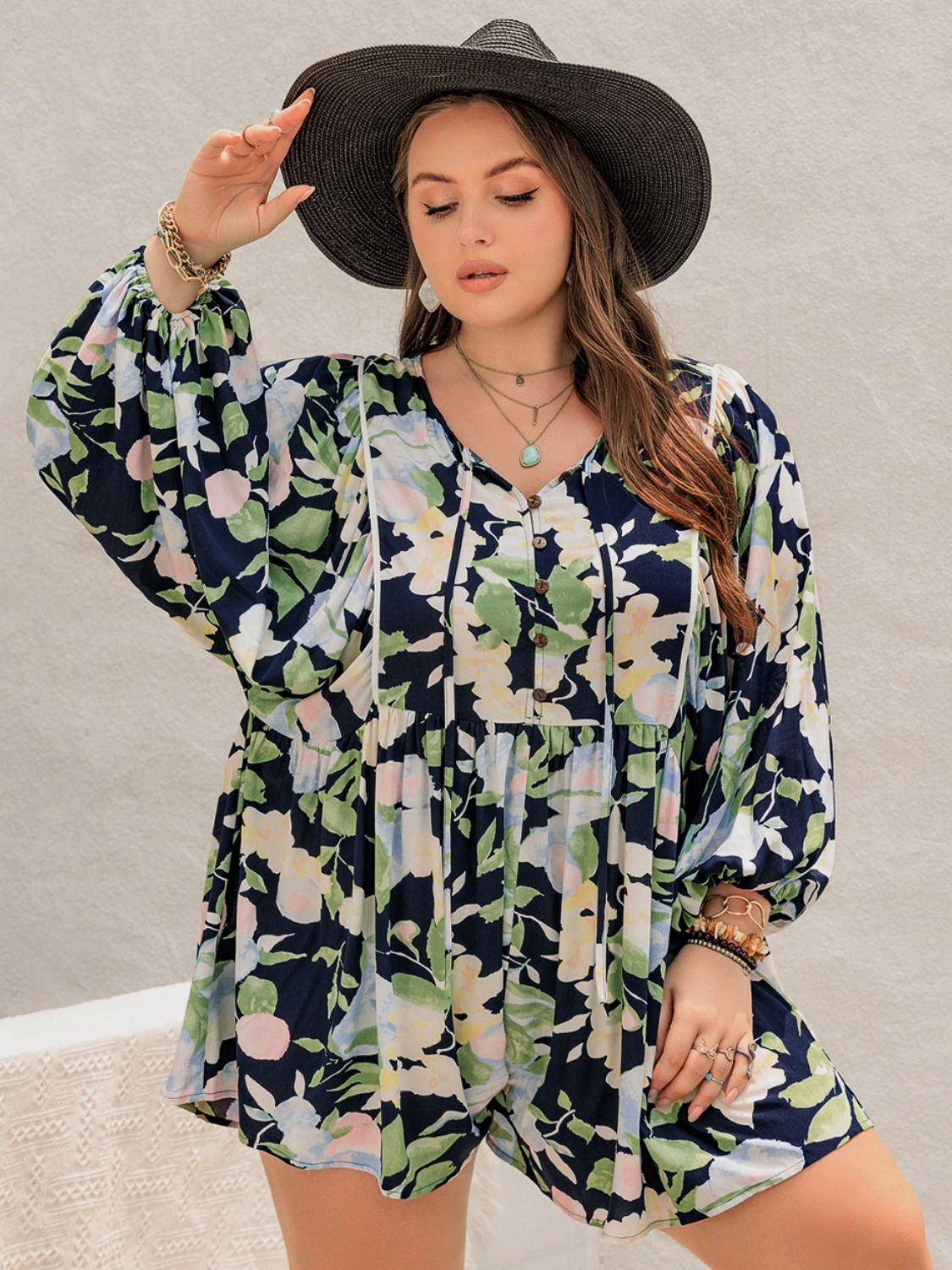 Front view of Plus Size Tied Printed Long Sleeve Romper in Pastel  Blue showing neckline and sleeve details