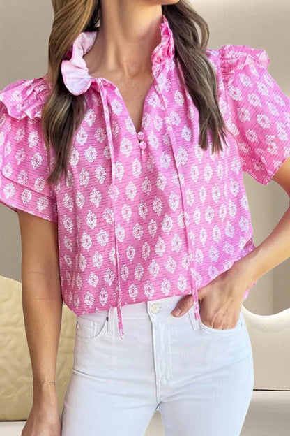Front view of Ruffled Printed Tie Neck Short Sleeve Blouse in Fuchsia Pink showing neckline and sleeve details